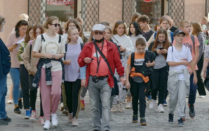 3 - A crowd of people walking down a city street, on a guided tour